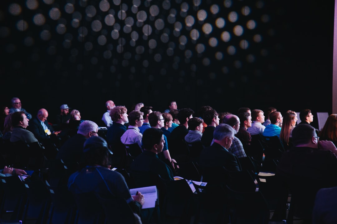 Business conference audience and speaker. Photo by Headway on Unsplash.