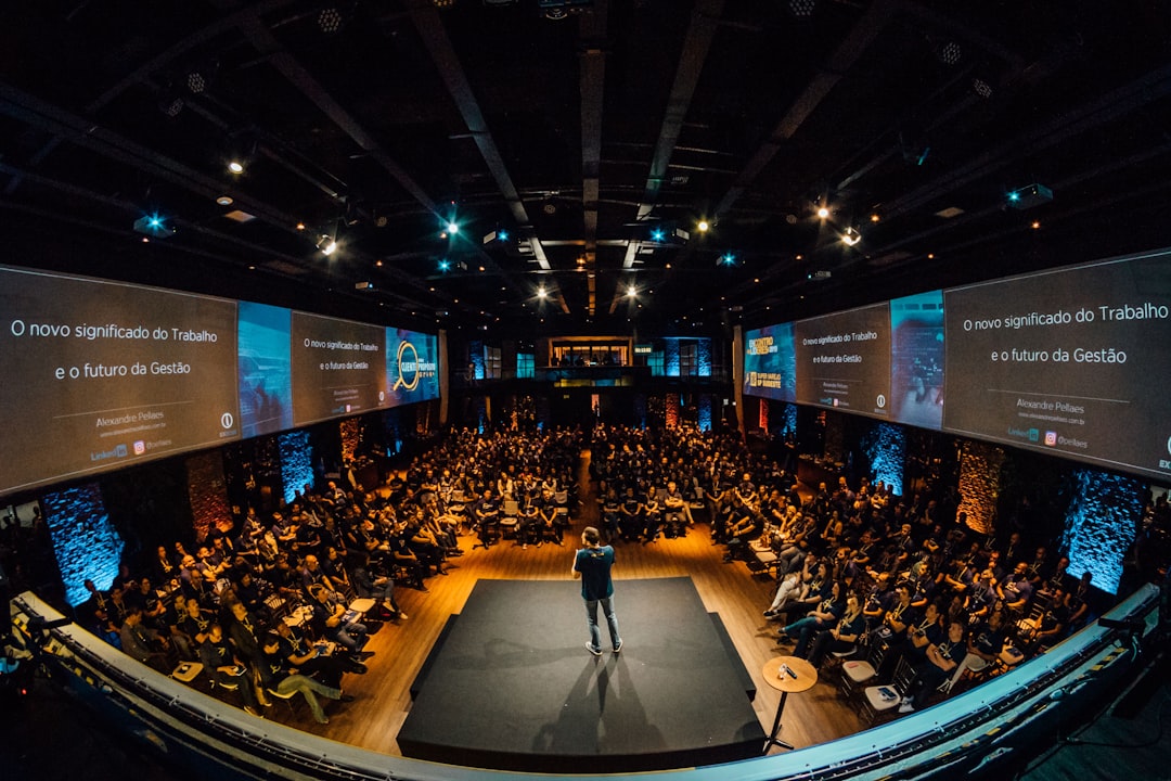 Speaker presenting to a conference audience. Photo by Alexandre Pellaes on Unsplash.